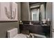 Stylish powder room features a dark vessel sink, stone countertop, decorative mirror, and modern toilet at 2797 Turtle Head Peak Dr, Las Vegas, NV 89135