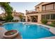 Gorgeous backyard featuring a pool, spa, and covered patio with lush green grass at 2837 Turtle Head Peak Dr, Las Vegas, NV 89135