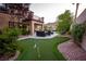 Beautiful backyard with putting green, covered patio, seating area, and mountain views at 2837 Turtle Head Peak Dr, Las Vegas, NV 89135