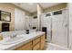 Bathroom with double sinks, white tile counter and shower, and brushed nickel fixtures at 2837 Turtle Head Peak Dr, Las Vegas, NV 89135