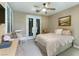 Comfortable bedroom with neutral tones, double doors, a ceiling fan, and ample natural light at 2837 Turtle Head Peak Dr, Las Vegas, NV 89135