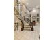 Magnificent curved staircase with elegant railing, high ceilings, and beautiful tile flooring create a grand entrance at 2837 Turtle Head Peak Dr, Las Vegas, NV 89135