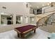 Elegant staircase with wrought iron railings, soaring ceilings, and a billiards table for recreation at 2837 Turtle Head Peak Dr, Las Vegas, NV 89135