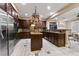Gourmet kitchen with stainless steel appliances, dark wood cabinetry, and an island with bar seating at 2837 Turtle Head Peak Dr, Las Vegas, NV 89135