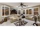 Comfortable living room featuring tile floors, a ceiling fan, and ample natural light from the large windows at 2837 Turtle Head Peak Dr, Las Vegas, NV 89135