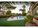 Sparkling pool and spa surrounded by lush landscaping, plants, and golf course in backyard at 2837 Turtle Head Peak Dr, Las Vegas, NV 89135