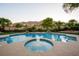 Inviting pool and spa area surrounded by lush landscaping, lighting, and mountain views at 2837 Turtle Head Peak Dr, Las Vegas, NV 89135