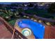 Stunning elevated view of a backyard pool with a built-in jacuzzi, lush landscaping, and well-lit surroundings at 2837 Turtle Head Peak Dr, Las Vegas, NV 89135