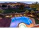 Gorgeous backyard pool and landscaping overlook golf course views and mountainous scenery at twilight at 2837 Turtle Head Peak Dr, Las Vegas, NV 89135