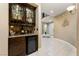 Chic wet bar featuring custom cabinetry, granite countertops, and a wine refrigerator at 2837 Turtle Head Peak Dr, Las Vegas, NV 89135