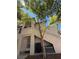 Exterior shot of a two-story condo building with a private entrance and mature tree at 3055 Key Largo Dr # 204, Las Vegas, NV 89120