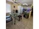 Kitchen and dining area features a glass dining table with seating, white cabinets, and modern appliances at 3055 Key Largo Dr # 204, Las Vegas, NV 89120