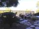 A desert landscape features a rock water feature, flagstone walkway, shrubs and wrought iron fence at 35 Emerald Dunes Cir, Henderson, NV 89052