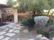A desert landscape features a flagstone walkway, mature trees and desert plantings at 35 Emerald Dunes Cir, Henderson, NV 89052