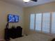 Comfortable bedroom featuring a TV, dresser, and window with white shutters at 35 Emerald Dunes Cir, Henderson, NV 89052