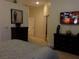 Bedroom features dual dressers, TV, artwork, and mirrored closet at 35 Emerald Dunes Cir, Henderson, NV 89052