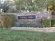 Landscaped entrance to Colony Lake community with stone wall, manicured hedges and sign at 35 Emerald Dunes Cir, Henderson, NV 89052