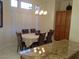Dining area featuring a chandelier, plantation shutters, and kitchen view, perfect for gatherings and meals at 35 Emerald Dunes Cir, Henderson, NV 89052
