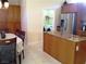 Well-equipped kitchen with tile flooring, central island, granite counters, and access to the laundry room at 35 Emerald Dunes Cir, Henderson, NV 89052