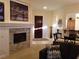 Cozy living room with a stone fireplace, comfortable seating, and views to the entryway and dining area at 35 Emerald Dunes Cir, Henderson, NV 89052