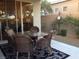 A round glass table with cushioned chairs sits on a tiled outdoor patio at 35 Emerald Dunes Cir, Henderson, NV 89052
