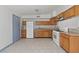 Well-lit kitchen with tile flooring, wooden cabinets, white appliances, and stylish backsplash at 3684 Hawaii Ave, Las Vegas, NV 89104