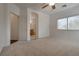 This carpeted main bedroom offers a glimpse of an en suite bathroom with double sinks and a glass shower enclosure at 3936 Pepper Thorn Ave # 3, North Las Vegas, NV 89081