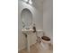 Neat powder room featuring a pedestal sink, oval mirror, modern lighting, and a toilet with a brown wooden seat at 3936 Pepper Thorn Ave # 3, North Las Vegas, NV 89081
