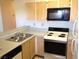 Well-lit kitchen featuring wood cabinets, a white range, and a built-in microwave at 4050 Pacific Harbors Dr # 214, Las Vegas, NV 89121