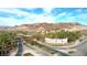 Inviting community entrance featuring lush palm trees, a decorative bridge, and clear signage under a blue sky at 47 Strada Principale, Henderson, NV 89011