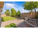 Backyard featuring hardscape, lush landscaping, and stone planter that adds beauty to the outdoor space at 5115 Morning Splash Ave, Las Vegas, NV 89131