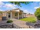 A beautifully landscaped backyard with artificial turf, brickwork, and a covered patio area at 5115 Morning Splash Ave, Las Vegas, NV 89131