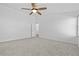 A spacious bedroom featuring neutral carpet, white walls, and a ceiling fan with a light fixture at 5115 Morning Splash Ave, Las Vegas, NV 89131