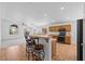Bright kitchen with tile flooring, breakfast bar, and wood cabinets, seamlessly connected to living area at 5115 Morning Splash Ave, Las Vegas, NV 89131