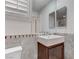 Updated bathroom featuring a single sink vanity with dark wood cabinet and neutral tiling at 5811 Pack Trl, Las Vegas, NV 89118