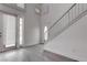 Bright foyer featuring sleek flooring, a modern staircase, and an entryway door with glass detail, creating a welcoming ambiance at 5811 Pack Trl, Las Vegas, NV 89118