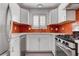 Modern kitchen with white cabinets, stainless steel appliances, quartz countertops, and red backsplash at 5811 Pack Trl, Las Vegas, NV 89118