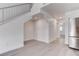 Bright living area adjacent to kitchen featuring gray wood-look flooring and a modern staircase at 5811 Pack Trl, Las Vegas, NV 89118
