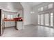 Open-concept living area showcasing a modern kitchen, ample natural light, and sleek gray flooring throughout at 5811 Pack Trl, Las Vegas, NV 89118