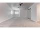 Spacious main bedroom with plush carpet, ceiling fan, and large window with shutter at 5811 Pack Trl, Las Vegas, NV 89118