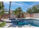 Inviting outdoor pool with pristine tile, mature greenery, and a serene backyard setting at 5811 Pack Trl, Las Vegas, NV 89118