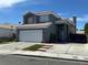 Two-story home with a blue-gray exterior, white garage door, and desert landscaping at 6208 Mandarin Dr, Las Vegas, NV 89108