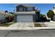 Two-story home with a blue-gray exterior, white garage door, and desert landscaping at 6208 Mandarin Dr, Las Vegas, NV 89108