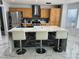 Modern kitchen featuring a marble island with seating, stainless steel appliances, and wood cabinets, offering style and functionality at 6208 Mandarin Dr, Las Vegas, NV 89108