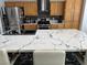 Modern kitchen featuring a large island with a marble countertop, stainless steel appliances, and wooden cabinets at 6208 Mandarin Dr, Las Vegas, NV 89108
