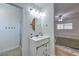 White vanity with a round mirror and shower room with a sliding glass door at 6920 Singing Dunes Ln, Las Vegas, NV 89145