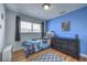 Blue bedroom with modern furnishings, a window with blinds, and laminate flooring at 6920 Singing Dunes Ln, Las Vegas, NV 89145