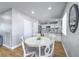 Open-concept dining area featuring white table and chairs and a view into the kitchen at 6920 Singing Dunes Ln, Las Vegas, NV 89145