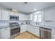 Bright kitchen featuring white cabinets, stainless steel appliances, and granite countertops at 6920 Singing Dunes Ln, Las Vegas, NV 89145