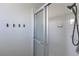 Shower room with white tile, sliding glass door, and black towel hooks on the wall at 6920 Singing Dunes Ln, Las Vegas, NV 89145